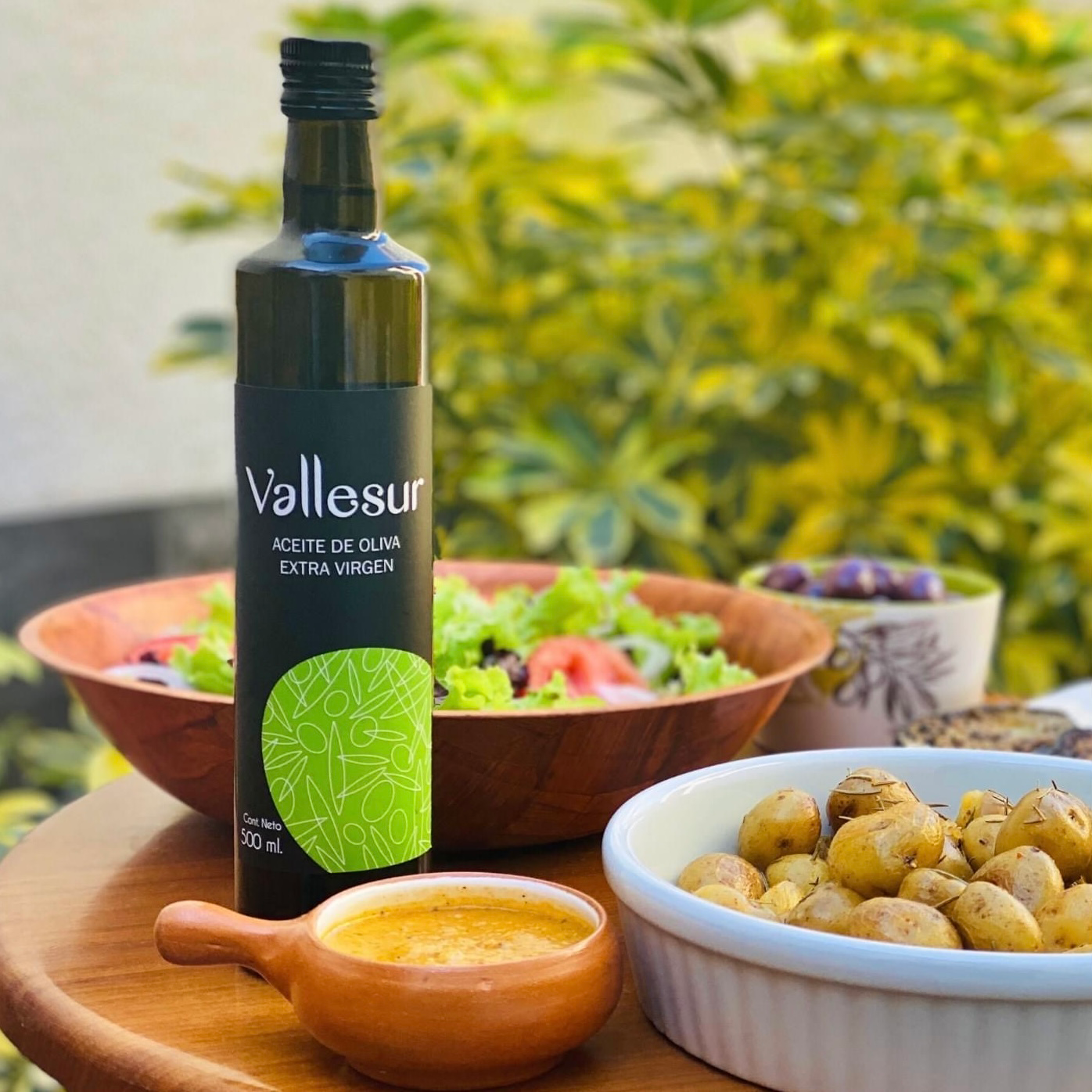 Fresh olives and branch with Vallesur EVOO bottle.